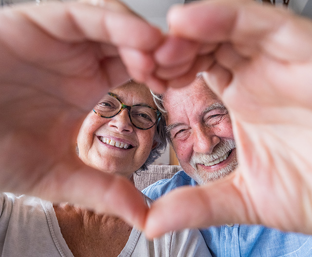 Old couple making heart with hands / selfie